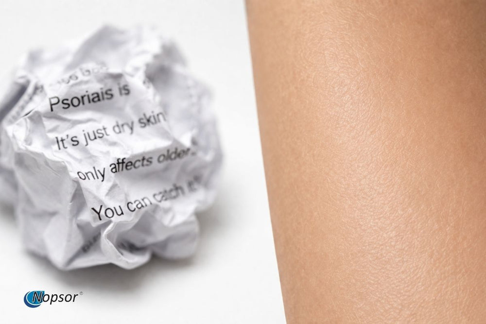 Ball of paper with text about psoriasis next to a close-up of skin